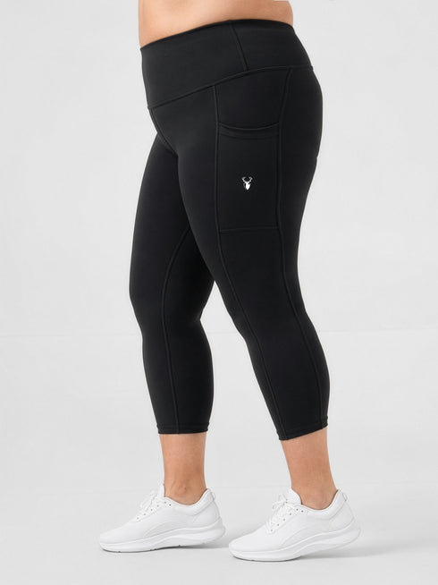 Leera black plus size capri pocket legging side view with white sneakers