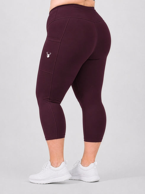 Leera maroon plus size capri pocket legging back view with white sneakers